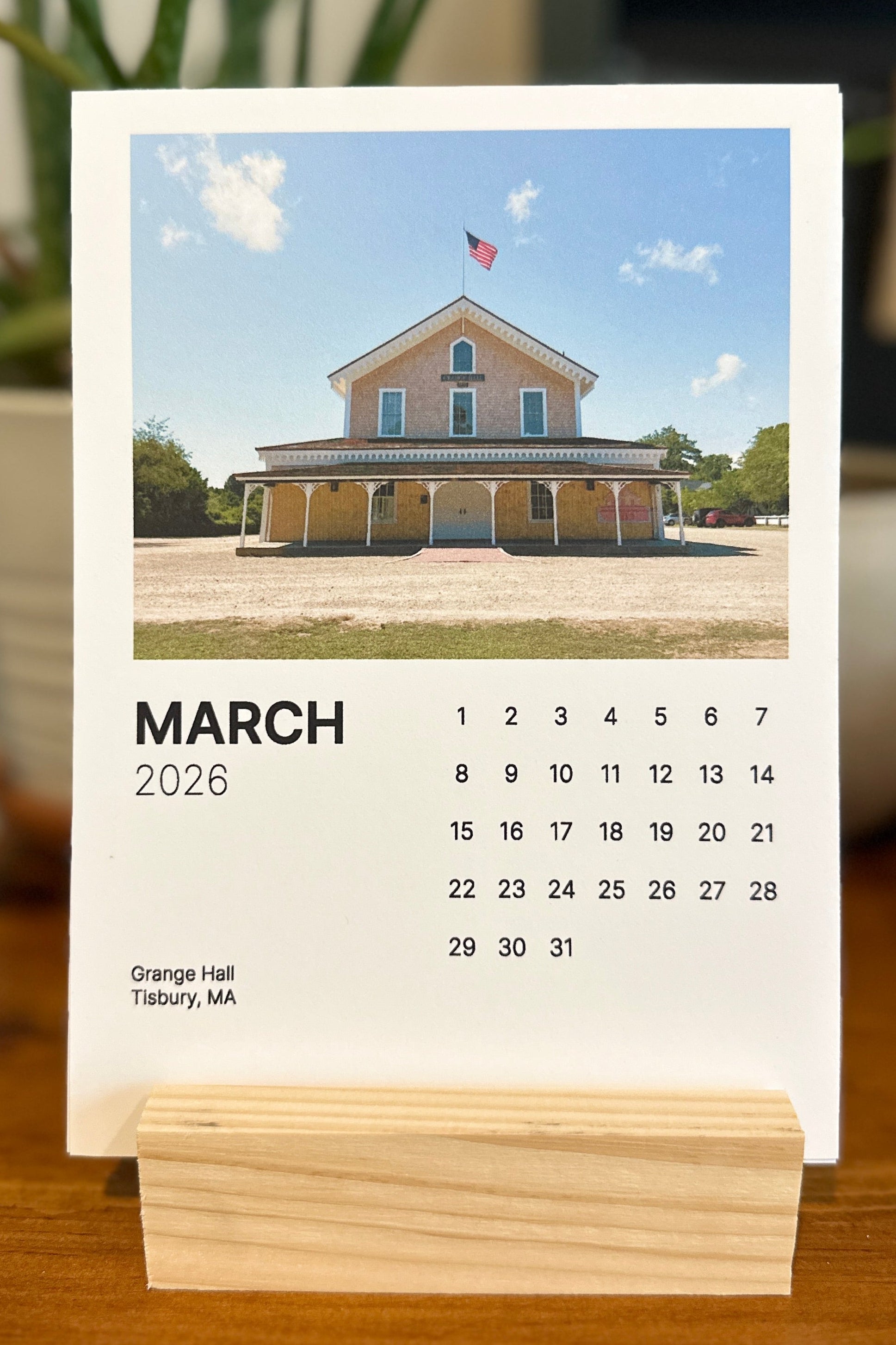 Calendar for March 2026 with a house image on a wooden stand